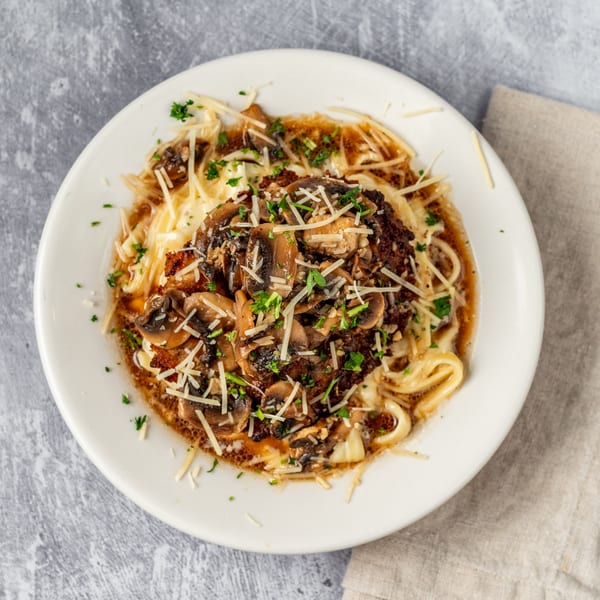Pacioni's Pizzeria's Chicken Marsala, featuring chicken, mushrooms, and pasta, topped with parmesan and parsley.